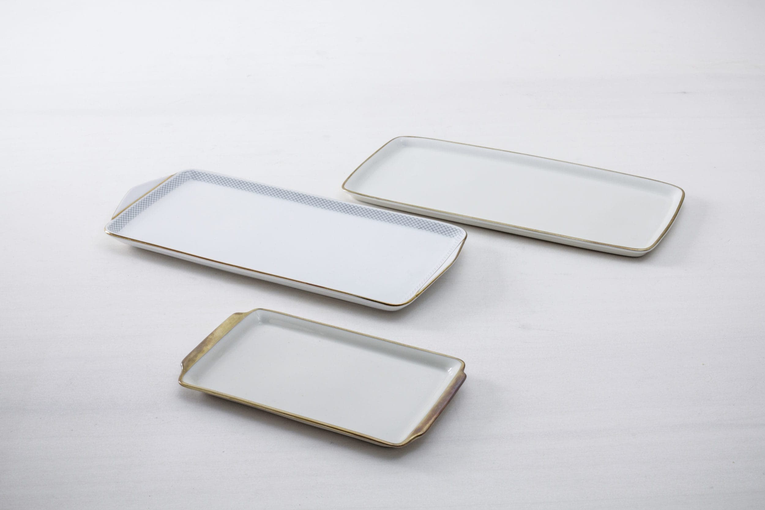 Unsere Kuchenplatten aus zartem, weißen Porzellan mit glänzendem Goldrand setzten vom Kuchen über Cupcakes bis zu zarten Petit Fours alles perfekt in Szene. Aber auch zum Arrangieren von kleinen Blumenvasen oder als Minitablett für Schnapsgläschen eignen sich die Servierplatten ideal. Dazu passen unsere vintage Kuchenteller Carmen und unser vintage Silberbesteck Antonia.