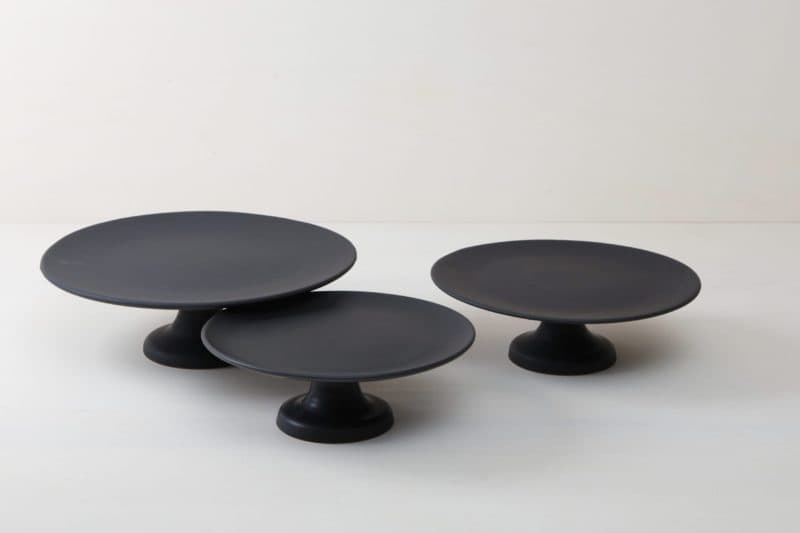  | Our large round elevated cake stand Ernesta rests on a 15 cm high foot and has a diameter of 40 cm. On the matt black serving tray there is enough space to present and arrange cakes, cupcakes, sushi and other delicious food on the table or at the modern buffet. The serving trays are handcrafted from high-quality terracotta and glazed matt black, obviously food safe.These cake stands are available in three different sizes as well as a matt white serving tray. They can be wonderfully combined ... | 