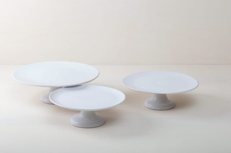  | Our medium size elevated cake stand Ernesta rests on a 13 cm high foot and has a diameter of 35 cm. Enough space to present and serve cakes, cupcakes, sushi and other delicious food on the table or at the modern buffet. The serving trays are handcrafted from high-quality terracotta and glazed matt white, of course food safe.These cake stands are available in three different sizes as well as a matt black serving plate. They can be wonderfully combined for presentations. | 
