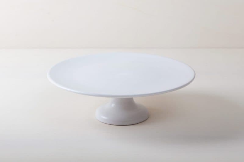  | Our large round elevated cake stand Ernesta rests on a 15 cm high foot and has a diameter of 40 cm. Enough space to present and serve cakes, cupcakes, sushi and other delicious food on the table or at the modern buffet. The serving trays are handcrafted from high-quality terracotta and glazed matt white, of course food safe.These cake stands are available in three different sizes as well as a matt black serving plate. They can be wonderfully combined for presentations. | 