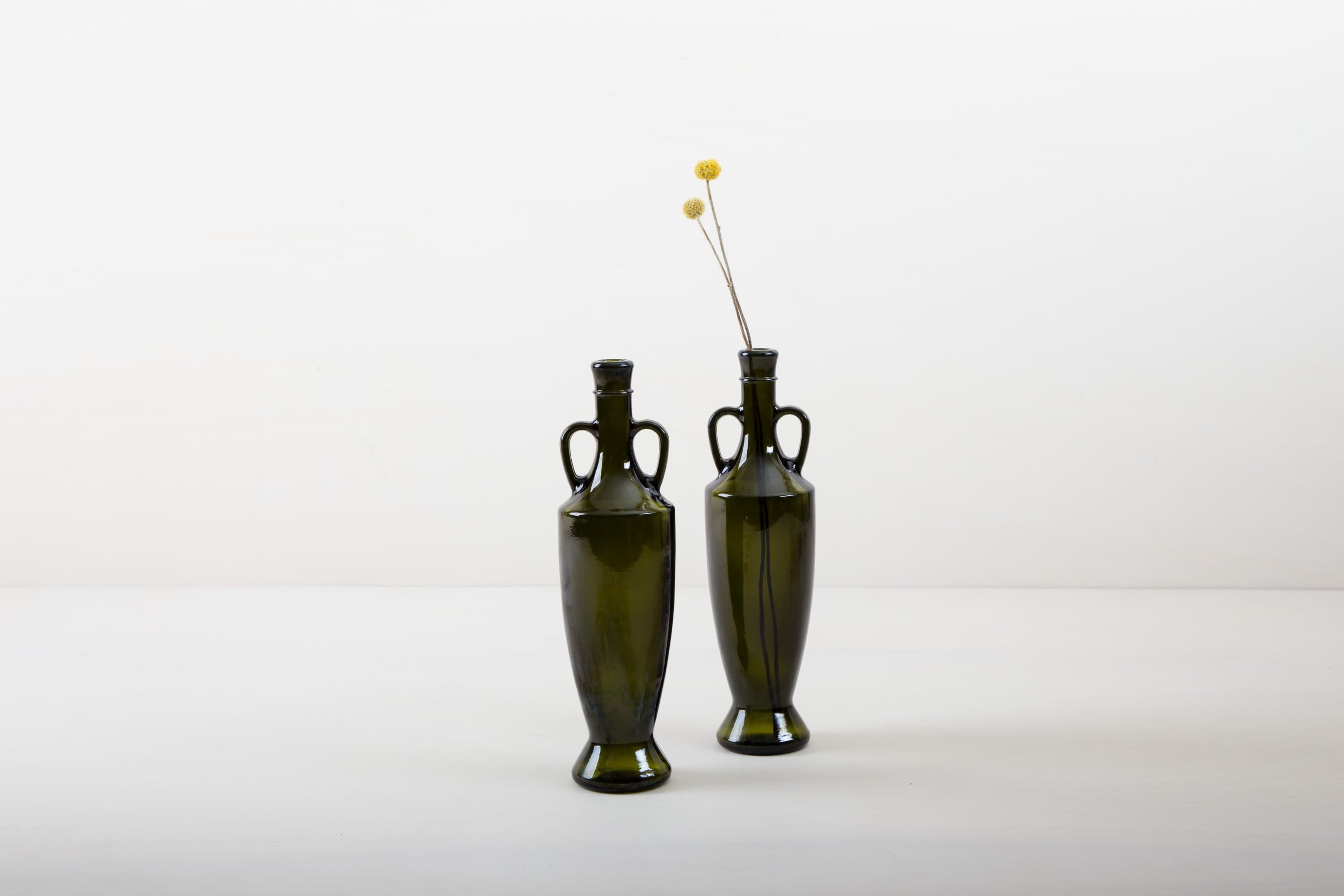 Unsere mehr als 80 Jahre alren Olivenölflaschen aus Süditalien sind die perfekte Ergänzung für jede Gartenparty, Sommerhochzeit oder edlem Dinner im mediteranen Flair. Bestückt mit kleinen Sträußen oder einzelnen Blumen, gibt die dunkelgrüne Glasvase Gonzales jeder Tischdekoration den letzten Schliff.